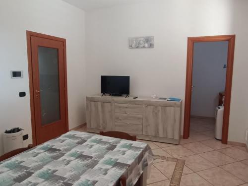 a room with a table and a tv on a wall at Locazione turistica Casa Peppe in Manduria