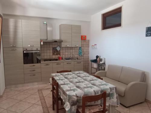 a kitchen with a table and a couch in a room at Locazione turistica Casa Peppe in Manduria