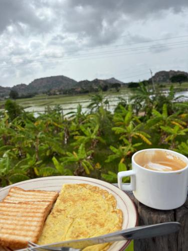 a plate of food with a cup of coffee and toast at Mowgli's Cafe Hampi & Guest House in Hampi