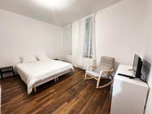una camera con letto, sedia e televisore di Appartement familial - jardin - PS4 a Montluçon