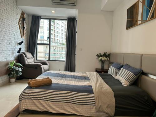 a bedroom with a bed and a chair and a window at Soho Apartment Central in District 1 in Ho Chi Minh City