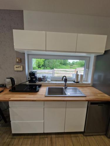 a kitchen counter with a sink and a window at Chill Chaty in Tarnobrzeg