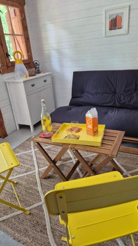 a living room with a yellow table and a couch at cabane bateau in Nort-sur-Erdre