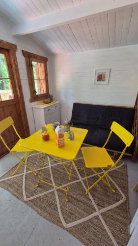 a yellow table and chairs in a living room at cabane bateau in Nort-sur-Erdre