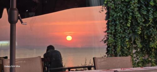 a person sitting at a table looking at the sunset at Dimora Acqua del Fico in Castellabate