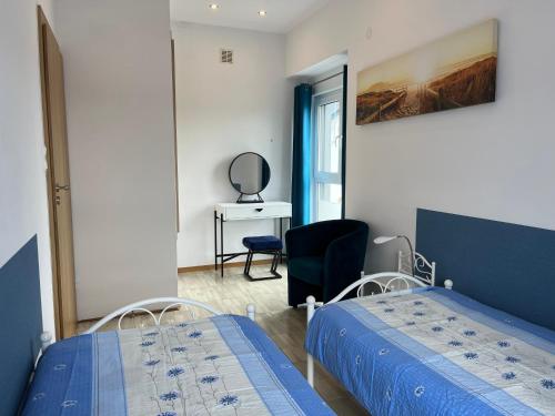 a bedroom with two beds and a chair and a desk at Apartamenty Kormoran in Sarbinowo