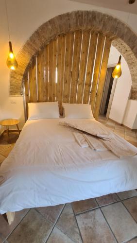 a bedroom with a white bed with a wooden wall at Molise Garden Apartments Renato in Boiano