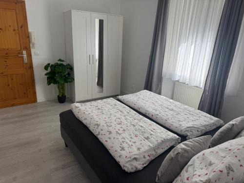 a bedroom with two beds and a door with a plant at Haus Maxim in Cochem