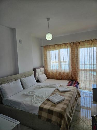 a bedroom with a large bed with a blanket on it at Vila Vako in Pogradec