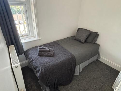 a small bed in a room with a window at 2 Bed Apartment Near Yeovil Hospital & Leonardo in Yeovil