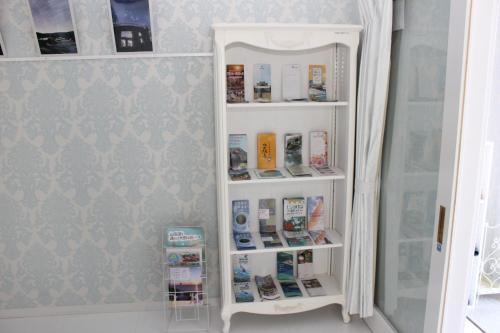 a book shelf with books on it in a room at 一棟貸しゲストハウス マリドール in Izumo