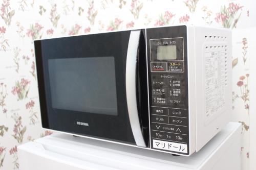 a microwave oven sitting on top of a white shelf at 一棟貸しゲストハウス マリドール in Izumo