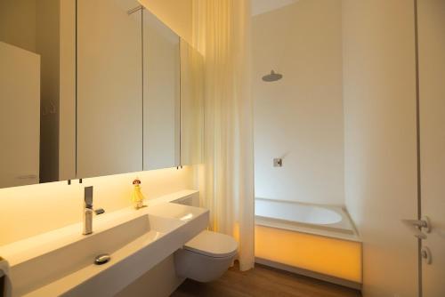 un bagno con lavandino, WC e vasca di Design apartment with view to Nemunas, Prienai a Pakopi