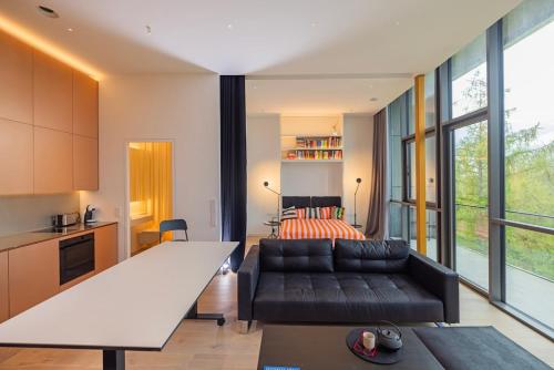 un soggiorno con divano e letto di Design apartment with view to Nemunas, Prienai a Pakopi