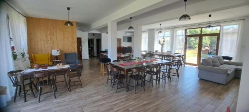 a living room with tables and chairs and a couch at Porumbacu381 - Casa de Oaspeti Faini in Porumbacu de Sus