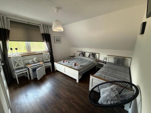 a bedroom with two beds and a table and a chair at U Marka in Dąbrowy