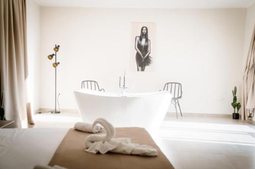 a bathroom with a bath tub and a swan towel at Cantine De Mare - Wine and Resort in Cirò Marina