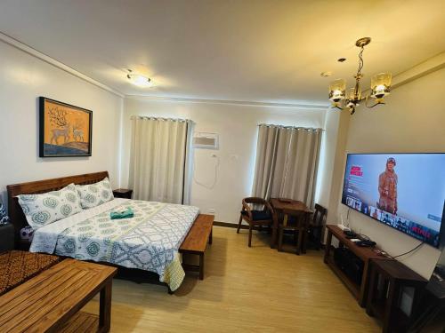 a bedroom with a bed and a flat screen tv at Happy Stays E - 300mbps - 65"TV NetFlix, Disney - Washer in Trece Martires
