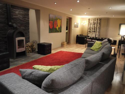 a living room with a large couch and a fireplace at Villa Maximus in Jáchymov