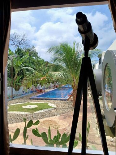 a camera looking out a window at a swimming pool at paparazzi homestay in Xuyên Mộc