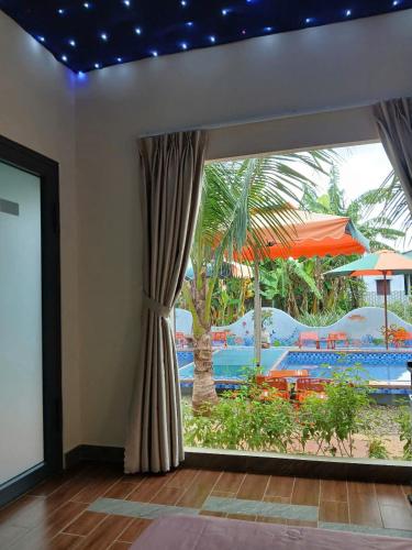 a room with a window with a view of a pool at paparazzi homestay in Xuyên Mộc