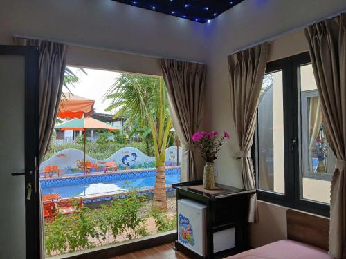 a room with a large window with a view of a pool at paparazzi homestay in Xuyên Mộc