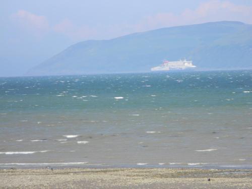 a large ship in the ocean with a beach at Harbour Lights Guesthouse in Stranraer