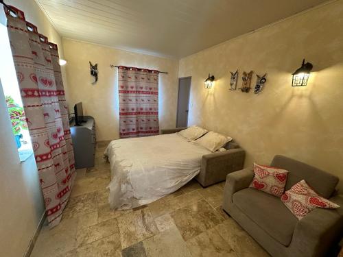 a small bedroom with a bed and a couch at gite de la chouette in Thyez