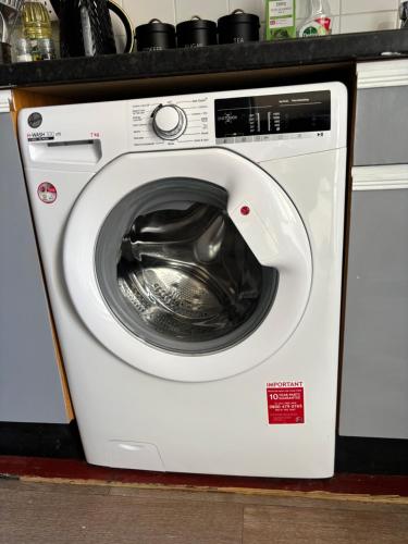 a white washing machine sitting in a kitchen at 2 Bed Apartment Near Yeovil Hospital & Leonardo in Yeovil