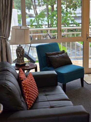 a living room with a couch and a chair at Cedar Grove Motor Lodge in Nelson