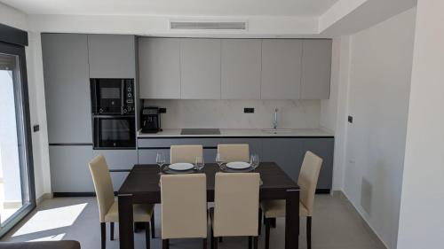 Una mesa de comedor con sillas y una cocina. en El Callejón, en Jaraguas
