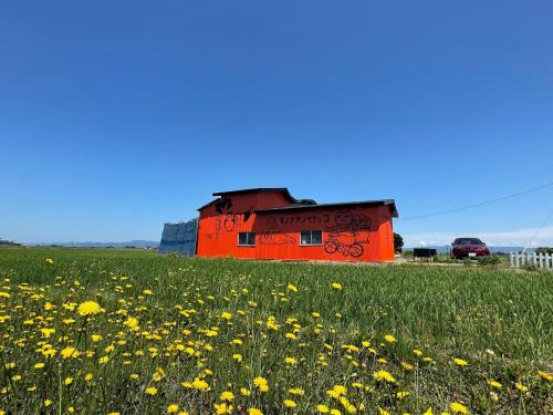 an orange building in a field of flowers at Tanonagano Yadokko - Vacation STAY 46380v in Goshogawara