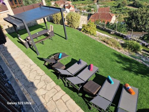 a picnic table and chairs on a lawn at O Piñón in Santa Cristina de Cobres