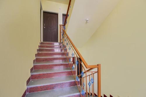 a stairway with a wooden door and a stair case at SPOT ON SR Dream Home in Goa
