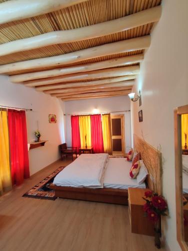 a bedroom with a bed and red and yellow curtains at Scenic ladakh homestay upper Tukcha leh in Leh