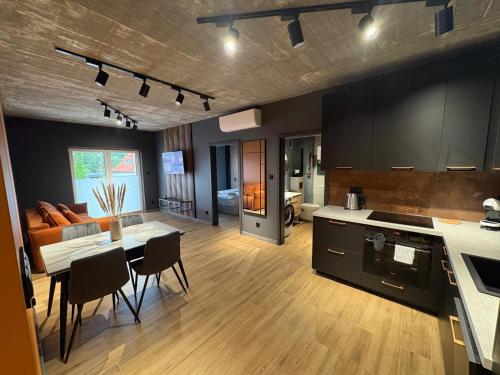 a kitchen and living room with a table and a couch at Apartament Baltic 13 Mielno in Mielno