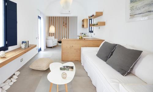 a living room with a white couch and a table at Amor Hideaway Villas in Fira