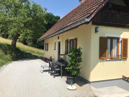 a house with a table and chairs in front of it at Ferienhaus Neuhold in Kitzeck im Sausal