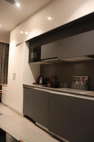 a kitchen with black and white cabinets and a counter at The Arc - Supernova in New Delhi