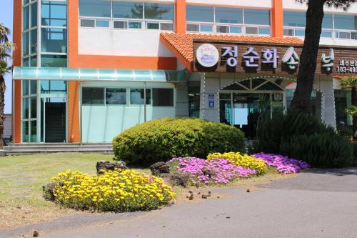 a building with flowers in front of it at Jeju Feel House in Jeju