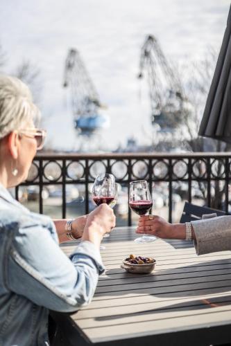 two people sitting at a table with glasses of wine at First Hotel Statt Örnsköldsvik in Örnsköldsvik