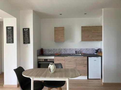 une cuisine avec une table en bois et une table et des chaises dans l'établissement Villa Type 2, à Bastia