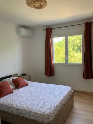 a bedroom with a bed and a window at Villa Type 2 in Bastia