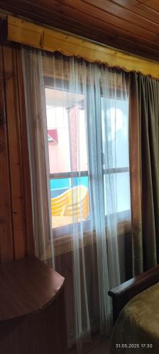 a bedroom with a window with curtains at Ana hotel in Ureki