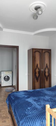 a bedroom with a bed with a blue blanket and a microwave at Ana hotel in Ureki