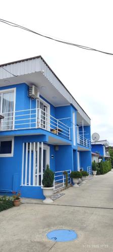 a blue building with a balcony on the side of it at Ana hotel in Ureki