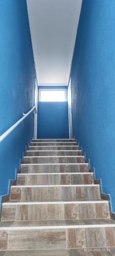 a staircase in a building with a blue wall at Ana hotel in Ureki