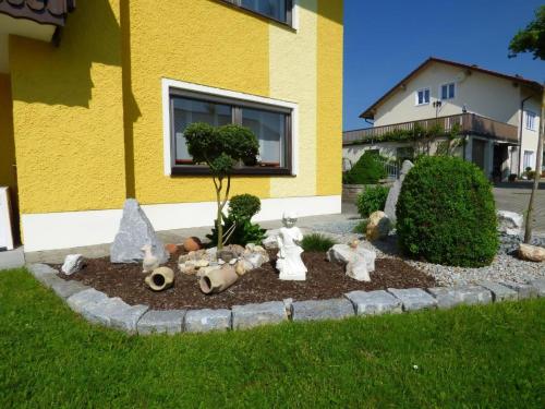 a garden with stuffed animals in the grass in front of a house at Komfortable Ferienwohnung Mit Garten Und Grill in Gleißenberg