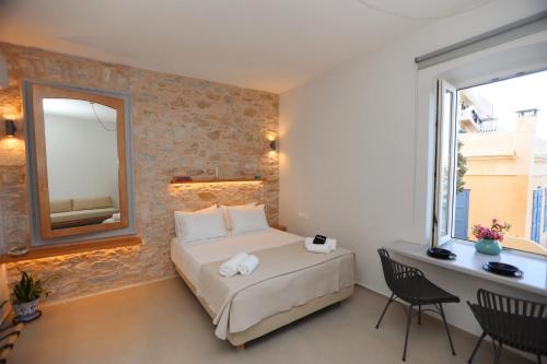 a bedroom with a bed with a mirror and a desk at Hermosa Seaside Living in Ermoupoli