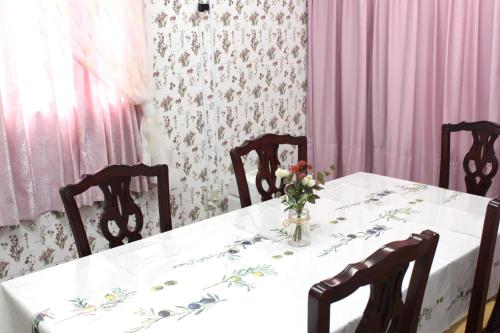 a dining room table with a vase of flowers on it at 一棟貸しゲストハウス マリドール in Izumo
